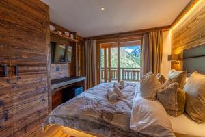 ein Schlafzimmer mit einem großen Bett mit Fenster in der Unterkunft Chalet Wooden Pearl - Ultimate Luxury & Privacy! in Saas-Fee