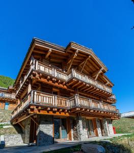 ein großes Holzhaus mit Holzbalkonen darauf in der Unterkunft Chalet Wooden Pearl - Ultimate Luxury & Privacy! in Saas-Fee