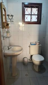 une salle de bain avec toilettes, lavabo et fenêtre dans l'établissement Casa Serra Azul, à Campos do Jordão
