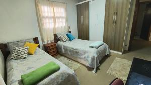 - une chambre avec 2 lits et un oreiller vert dans l'établissement Casa Serra Azul, à Campos do Jordão