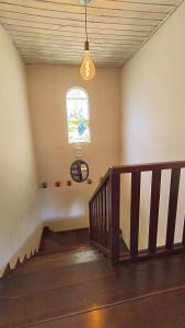 une pièce vide avec un escalier et une fenêtre dans l'établissement Casa Serra Azul, à Campos do Jordão