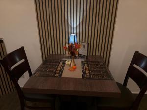 a wooden table with a vase of flowers and a lamp at Hotel zum Sportforum in Blankenburg