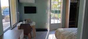 a room with a bed and a table and a television at Studio bois du bournat piscine et tranquilité in Saint-Avit-Sénieur +9 photos