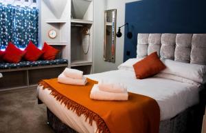 a bedroom with a large bed with towels on it at The Jacobean Hotel in Coventry