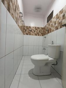 a white bathroom with a toilet and a sink at Tay Deling's Place in El Nido