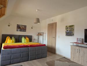 a bedroom with a large bed with colorful pillows at Pension Sommerfrische in Nebra