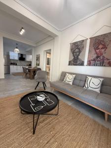 a living room with a couch and a table at Feels Like Home - Agrinio Suites in Agrinio