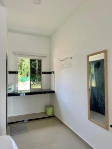 a white room with a mirror and a window at Inap Keranji Homestay With Pool in Kota Bharu