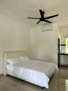 a bedroom with a bed with a ceiling fan at Inap Keranji Homestay With Pool in Kota Bharu