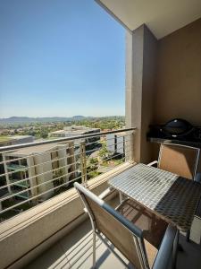 a balcony with a table and chairs and a view at The Capital Trilogy Hotel in Pretoria