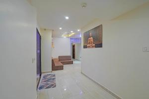 a hallway with a couch and a painting on the wall at FabHotel Rajtilak in Ahmedabad +18 photos