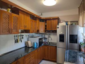 a kitchen with wooden cabinets and a white refrigerator at Holiday home in Zamardi - Balaton 54796 in Zamárdi