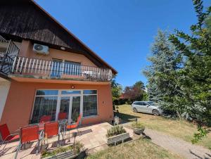 a house with chairs and a balcony and a car at Holiday home in Zamardi - Balaton 54796 in Zamárdi
