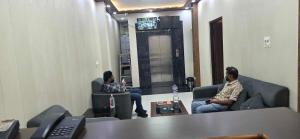 two men sitting on couches in a room at Hotel O Banaras Guest House in Banāras Cantonment