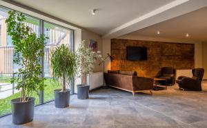 een lobby met een bank en een tv aan een bakstenen muur bij New Gudauri Atrium Apartments in Goedaoeri +5 foto's