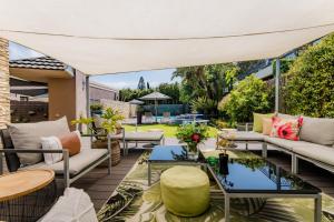 an outdoor patio with couches and tables at SW1 Lodge in Somerset West
