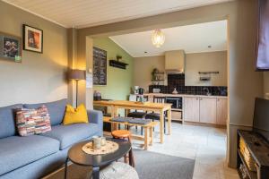 een woonkamer met een bank en een keuken bij Atlas Guesthouse in Brugge