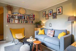 een woonkamer met een blauwe bank en een boekenplank bij Atlas Guesthouse in Brugge