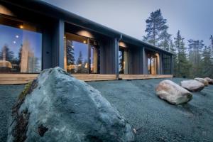 ein Haus mit einem großen Felsen davor in der Unterkunft Ruka Trek Gasthaus & Hard Trek Café in Kuusamo