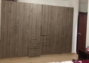 a large wooden cabinet in the corner of a room at Neema maison de Glamour in Entebbe