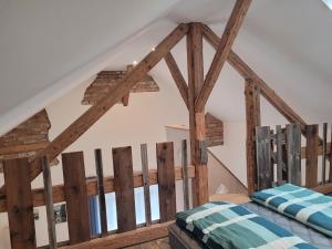 a bedroom with wooden beams in a attic at Ferienwohnung Lindenblüte in Eggenthal