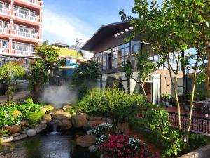 a garden with a pond in front of a building at Khu vườn của Nàng Đà Lạt - Le Jarden De Nàng in Da Lat