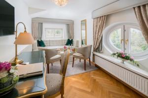 a dining room and living room with a table and chairs at Hotel Schloss Mönchstein in Salzburg