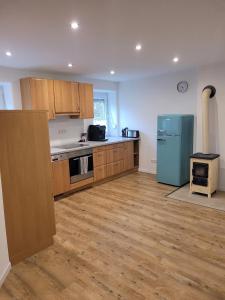 a kitchen with wooden cabinets and a blue refrigerator at Ferienwohnung Lindenblüte in Eggenthal +5 photos