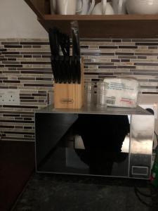 a knife block with a bunch of knives on it at Neema maison de Glamour in Entebbe