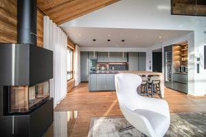 a kitchen with a white chair and a stove at Le Chalet Royal by Aavalevi in Levi