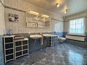 een grote badkamer met 2 wastafels en een toilet bij Ferienunterkünfte Familie Berger in Dessau