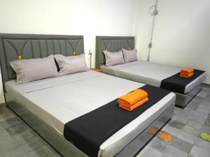 two beds in a room with orange towels on them at Passport Villa in Siem Reap +69 photos