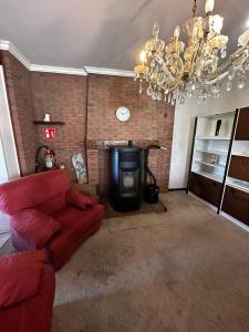 a living room with a red couch and a fireplace at White House in Ternat