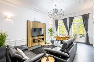 a living room with leather furniture and a television at Pyramide in Mulhouse