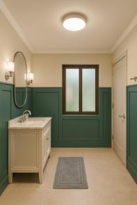 een groene badkamer met een wastafel en een spiegel bij Windmill Hostel in St Julian's +30 foto's