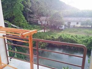 a balcony with a bench overlooking a river at lanta our home apartment in Ko Lanta Yai