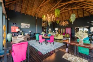 a living room with pink chairs and a table at SW1 Lodge in Somerset West