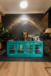 a blue credenza with a bust on a wall at SW1 Lodge in Somerset West