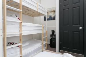 een slaapkamer met een stapelbed en een zwarte deur bij Rooms In Yorkway - KC17 in Londen