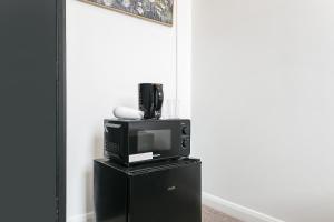een televisie bovenop een zwarte kast bij Rooms In Yorkway - KC17 in Londen