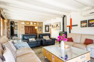 a living room with couches and a coffee table at Can Pessal in Es Carritxo