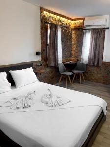 a bedroom with a bed with white sheets and chairs at Archontiko Kantilis in Díon +29 photos