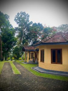 a small house with a brick road next to it at Sarangu VIlla in Akuressa
