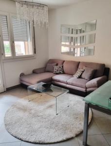 een woonkamer met een bruine bank en een glazen tafel bij Maison Carducci in Imola
