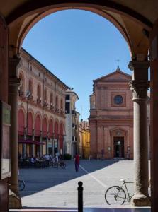 een open boog in een stad met een gebouw bij Maison Carducci in Imola