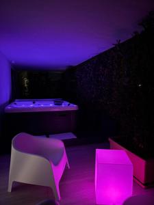 a purple room with a tub and a chair at Cremona Inn Aparthotel in Cremona