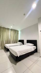 a bedroom with two beds and a window at Melody Inn Hotel in Kluang