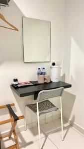 a desk with a chair and water bottles on it at Melody Inn Hotel in Kluang