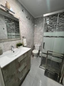 a bathroom with a sink and a shower and a toilet at Ground floor apartment with terrace and pool in La Mata