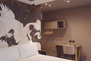 a bedroom with a bed and a table with a chair at Didimos Town Hotel in Reggio Calabria